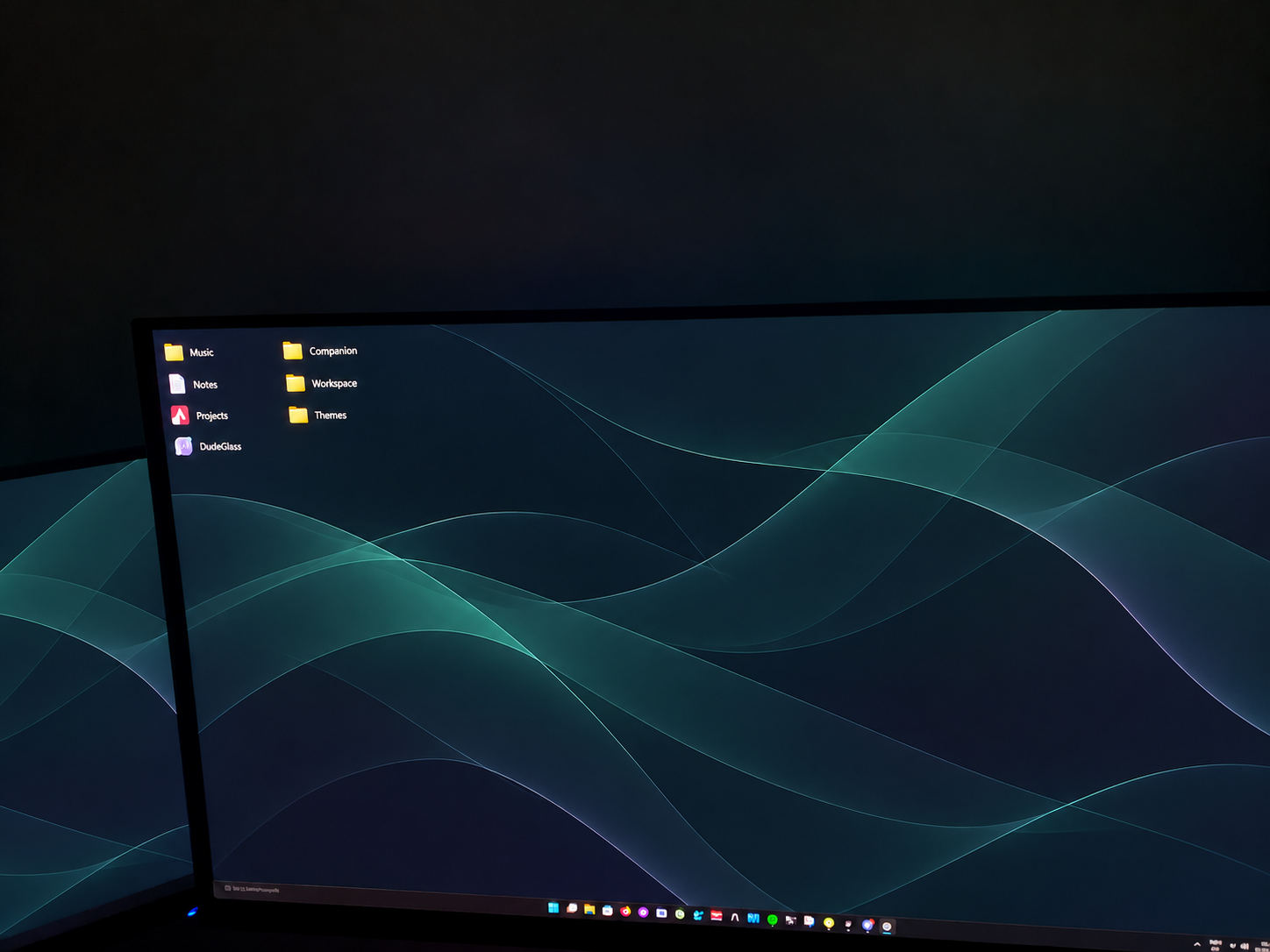 Edited owner photograph showing part of the creator’s triple-monitor workspace, with generic shortcuts and the DudeGlass theme.
